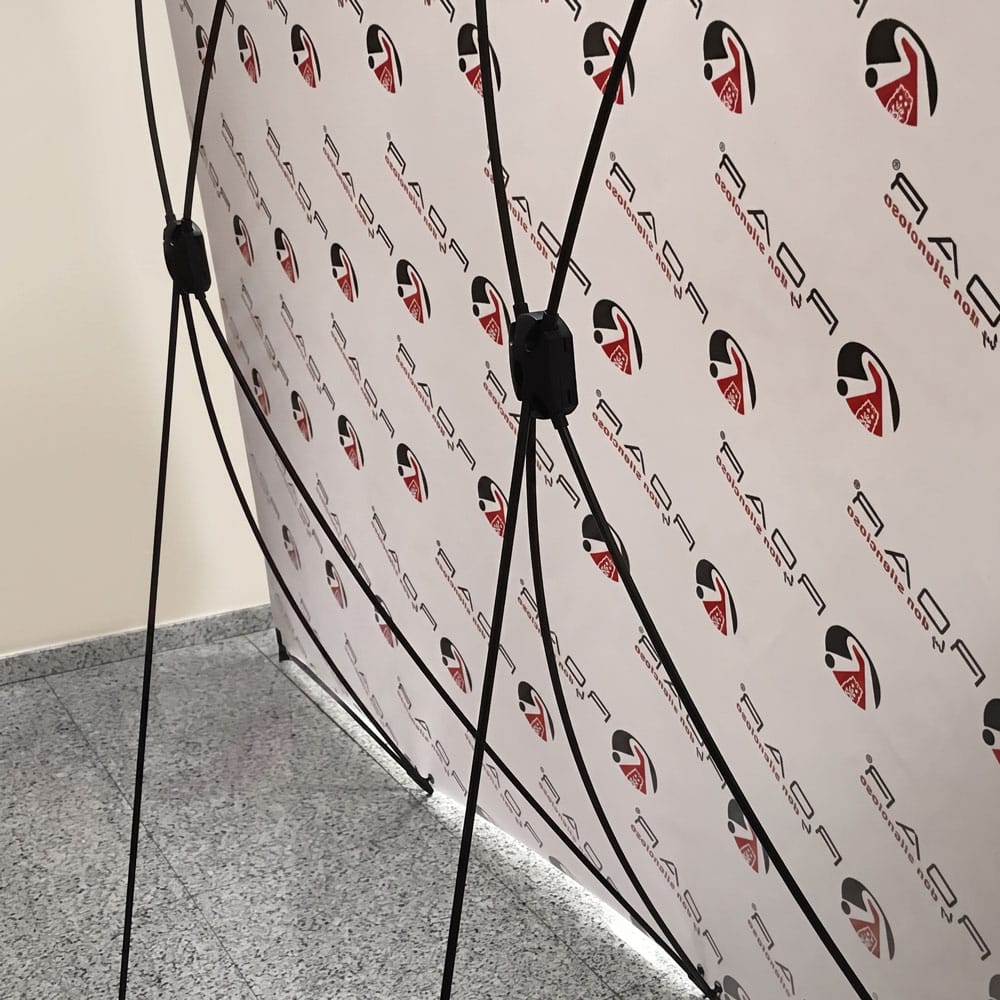 Estructura X-banner del photocall vista por detrás, con las varillas cruzadas que tensan la lona